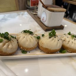 Wu’s Shanghai Dumpling signature dishes Shanghai Pan-Fried Pork Buns 上海⽣煎包
Pork Juicy Buns 猪⾁⼩笼包
Pork Wonton in Spicy P&B Sauce 红油抄⼿